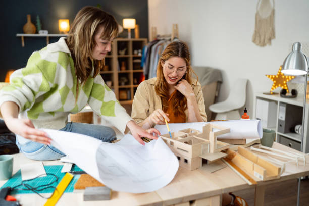 istock Two female architecture students making architectural model of a modern house 2058270510