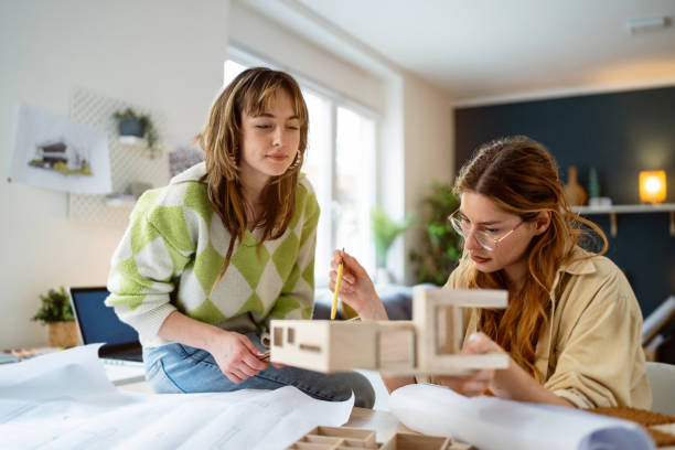 istock Two female architecture students making architectural model of a modern house 2058271588