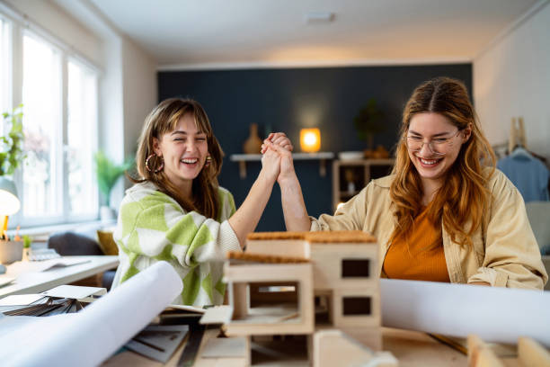 istock Two female architecture students making architectural model of a modern house 2058274237