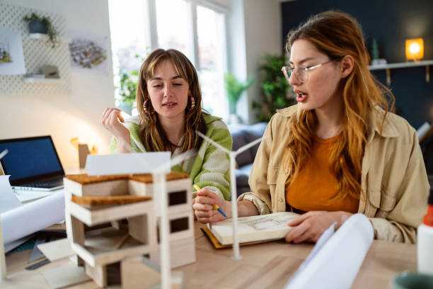 istock Two female architecture students making architectural model of a modern house 2058274770