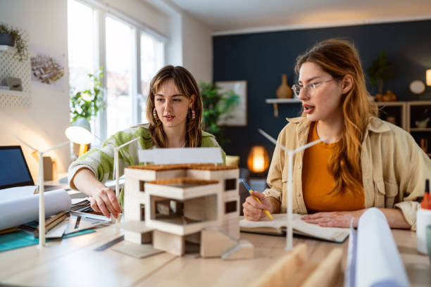 istock Two female architecture students making architectural model of a modern house 2058275300