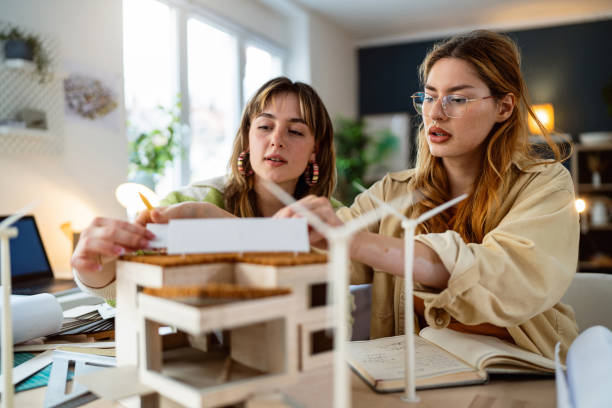 istock Two female architecture students making architectural model of a modern house 2058275828