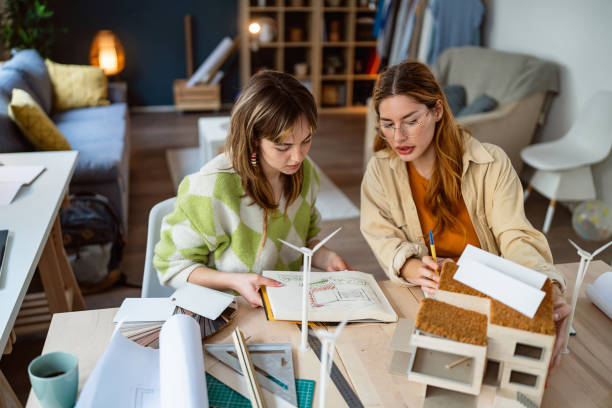istock Two female architecture students making architectural model of a modern house 2058275847