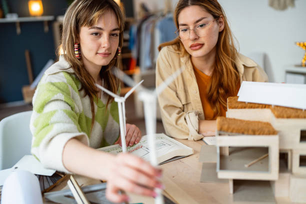 istock Two female architecture students making architectural model of a modern house 2058276386