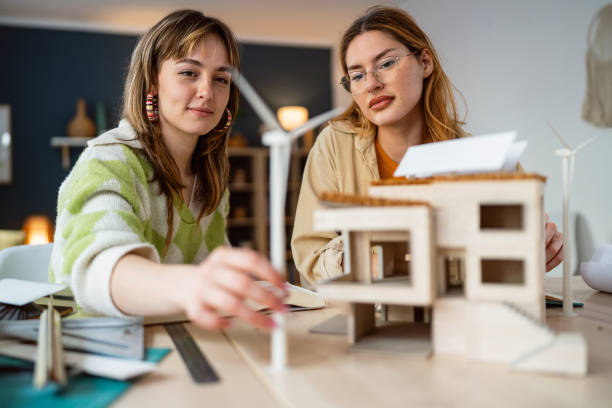 istock Two female architecture students making architectural model of a modern house 2058276471