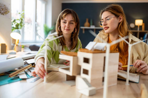 istock Two female architecture students making architectural model of a modern house 2058276918