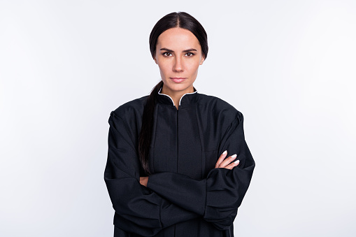 Photo of serious cool confident woman judge with folded hands wear black robe jurisdiction isolated on white color background