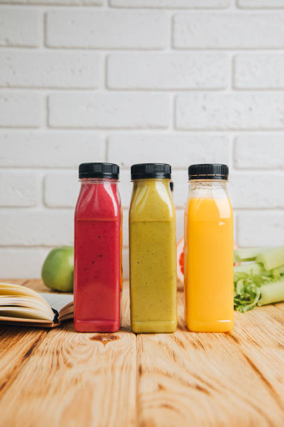 istock Fruit and vegetable smoothies in transparent plastic bottles. Red, green, orange smoothies on a wooden table. The concept of healthy eating 2058283490