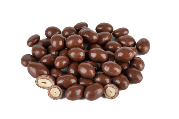 istock A bunch of dark chocolate peanuts isolated on a white background. 2058291585