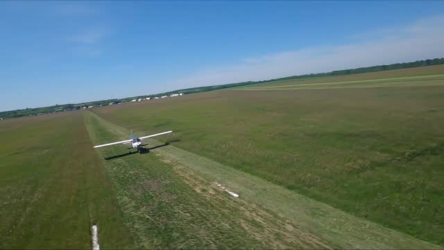 Small airplane riding along rural runway before the take-off. Light aircraft heading towards airstrip for before flight at airfield. Lightweight plane accelerating preparing to fly. Aviation concept