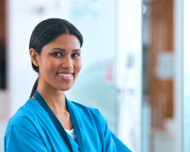 kopf- und schulterporträt einer lächelnden ärztin oder krankenschwester, die im krankenhaus peelings trägt - female nurse female doctor head and shoulders female stock-fotos und bilder