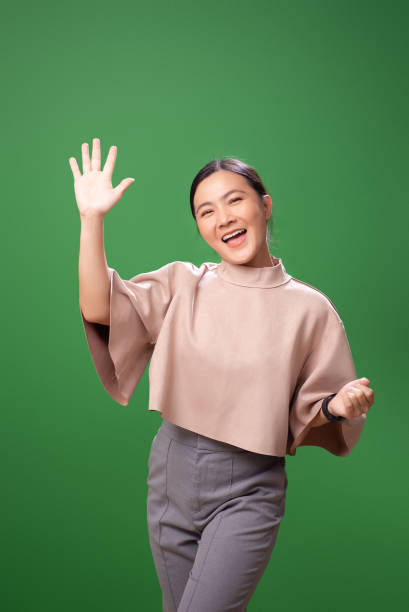 istock Asian woman smiling confidence making high five gestures, isolated on green background. 2058316150