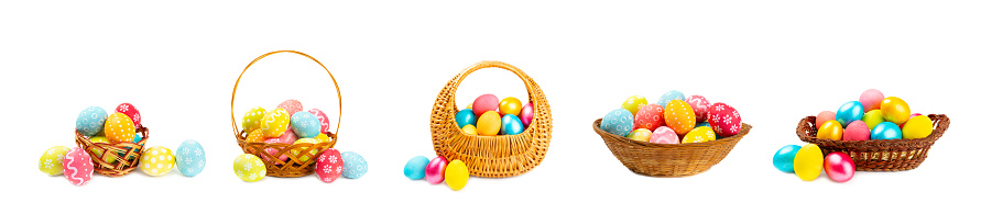 Easter eggs hand painted in a straw basket isolated on white with spring leaves