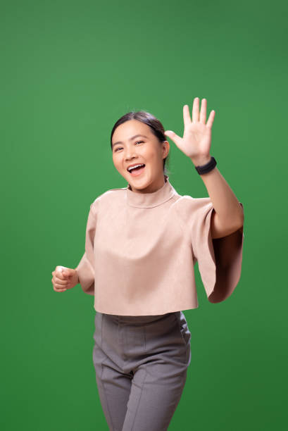 istock Asian woman smiling confidence making high five gestures, isolated on green background. 2058318901