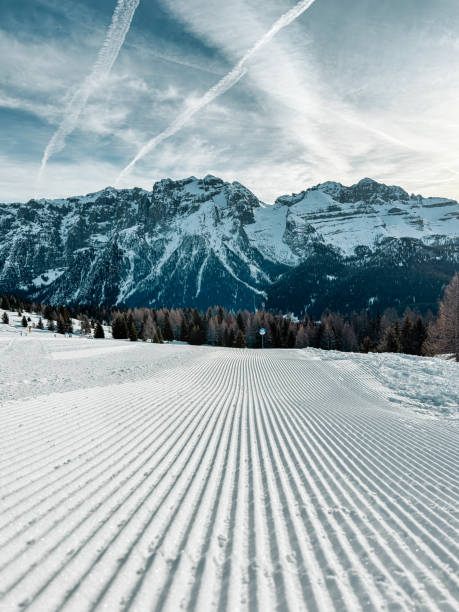 Fresh snow groomer tracks on a mountain ski piste.  Prepared ski and snowboard track with trace of snow groomer on snow at ski resort.