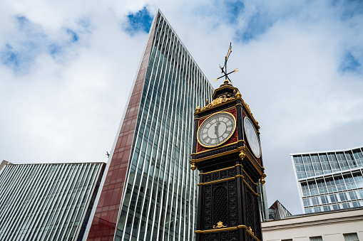 London, England-August 2022; View of the large analog clock on the platform of Kings Cross station with brick side of concourse and steel beams of the roof of the station