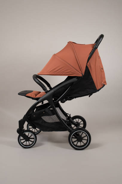 istock Orange baby carriage on light background 2058348832