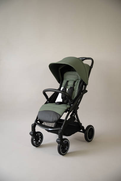 green baby carriage on a light background - poussette photos et images de collection