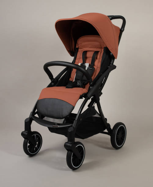 istock Orange baby carriage on light background 2058350266