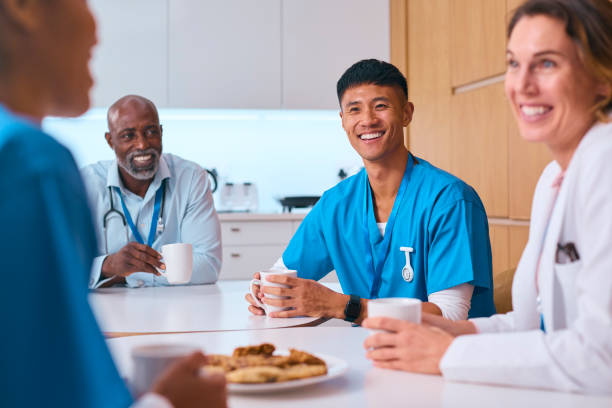 istock Multi Cultural Medical Team Taking Coffee Break In Modern Hospital Kitchen 2058352508
