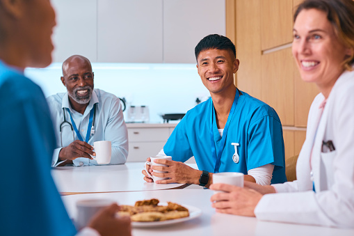 Multi Cultural Medical Team Taking Coffee Break In Modern Hospital Kitchen