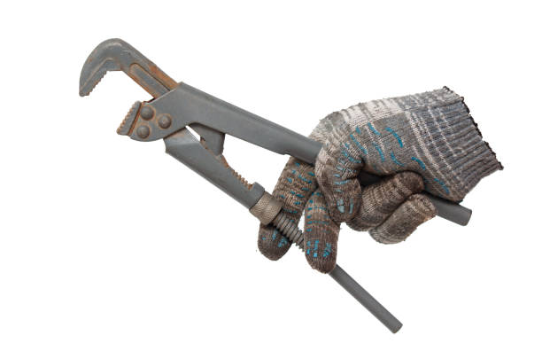 istock Plumber's hand in glove holding a pipe wrench isolated on white background 2058353193