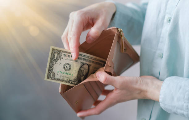 istock Personal Finances - Woman Taking a One Dollar Bill from Her Wallet 2058403359