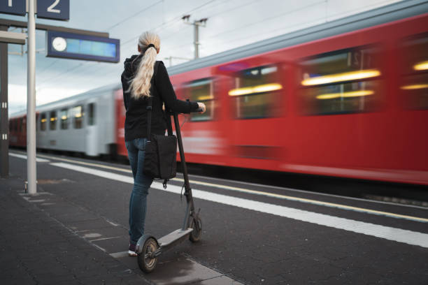 istock woman with electric scooter on platform blurred train passing 2058416855