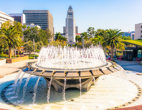 A fountain in Gloria Molina Grand Park, with Los Angeles City Hall in the distance.