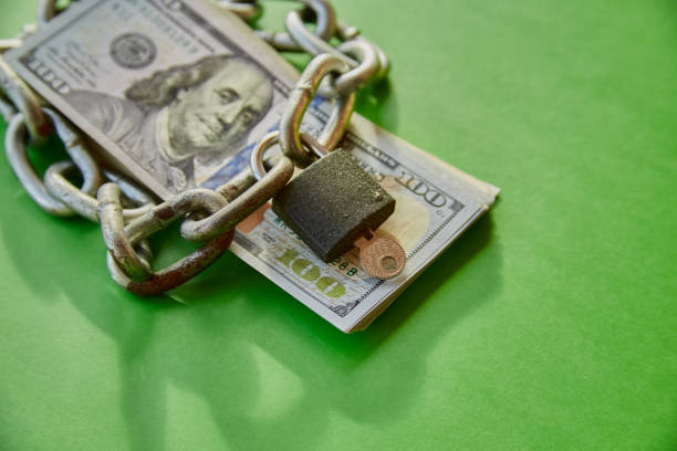 istock Hundred-dollar bills with a chain on them and a closed lock, blocking financial aid, blocking funds 2058418410