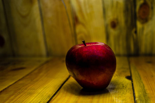 istock Fresh red apple on wood with warm light 2058421201