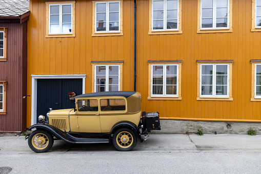 Roros - Norway. June 23, 2023: The nostalgic allure of Røros is captured with a retro automobile against the facades of this well-preserved Norwegian heritage town