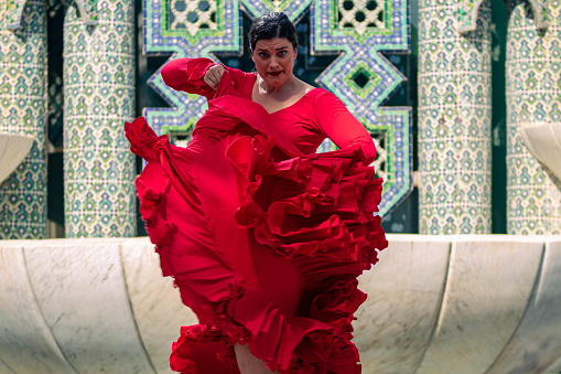 Female artist travels the world performing her traditional flamenco dances including traditional clothing