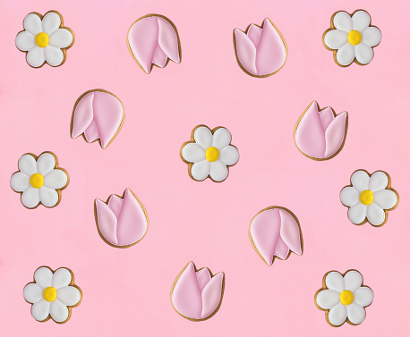 Gingerbread cookies in the shape of chamomile and tulip on the pink background. Top view. Copy space.