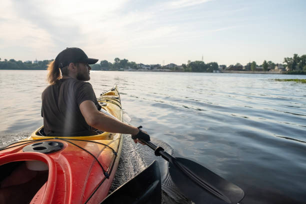 istock Athlete paddles along rivers surface in midst of summer warm glow 2058455368