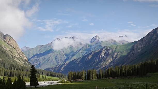 istock Snowy mountains and forests under a blue sky 2058456958
