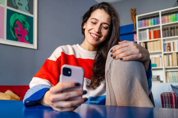 istock Entertainment at home - young woman using a smart phone 2058458562