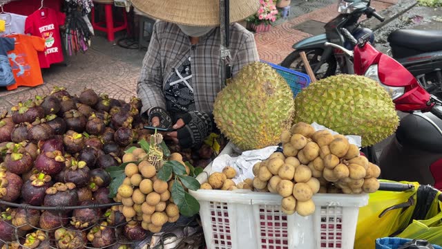Street vendors selling fruit in Vietnam Close up of asian fruits. Mangosteen, grapes in the market.