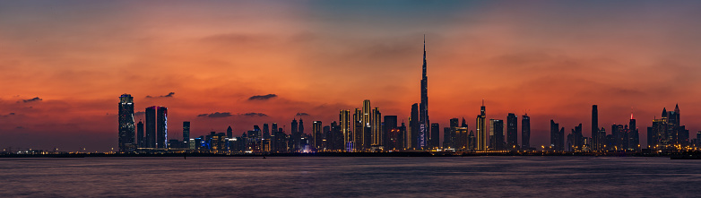 Dubai, United Arab Emirates - November 5, 2023: A panorama and colorful picture of Dubai at sunset, with the Burj Khalifa towering over the other high rises.