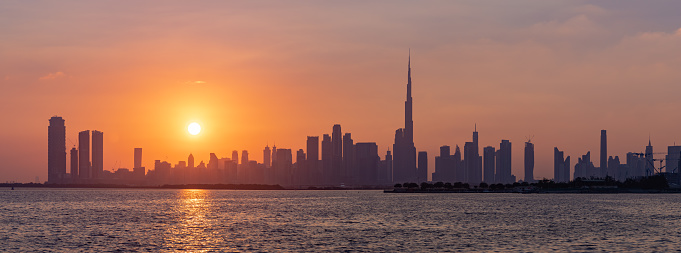 Dubai, United Arab Emirates - November 5, 2023: A panorama and colorful picture of Downtown Dubai at sunset, with the Burj Khalifa towering all high rises.