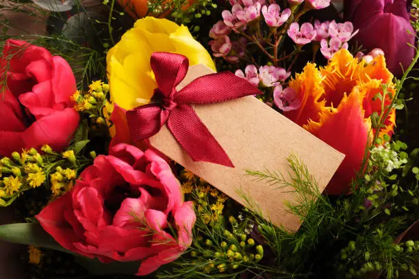 Colorful spring tulips with empty gifttag, present for March 8, International Women's Day, birthday