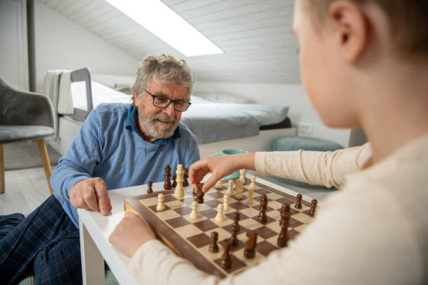 istock Grandfather playing chess with his Grandson at Home 2058565253