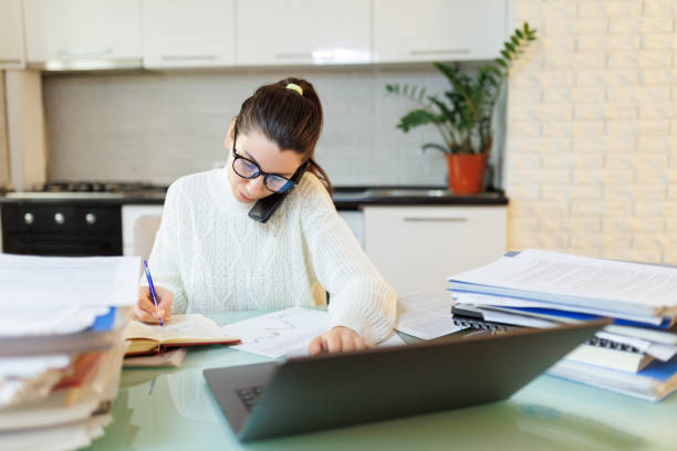istock Home Office Call Tired Woman in Glasses Talks on Phone During Work Break 2058565773