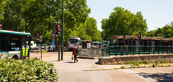 Vincennes, France - May 15, 2020: Woman wearing mask leaves bus station in Paris suburb. Coronavirus lockdown, deconfinement start (easing restrictions). Passengers in public transport must wear masks