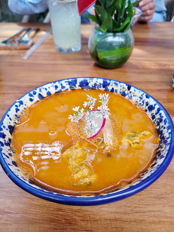 Vertical view of Hearty menudo soup, a Mexican culinary staple, garnished with fresh herbs