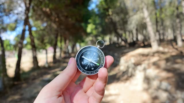 Person holding small compass in hand