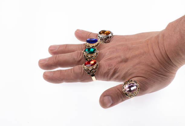 hand with a set of rings with colored stones isolated on white background