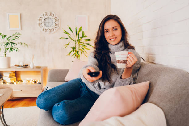 istock Woman watching tv at home 2058660396