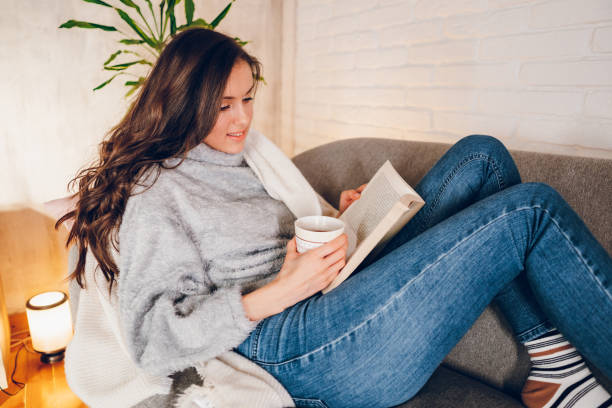 istock A woman is reading a book at home 2058661683