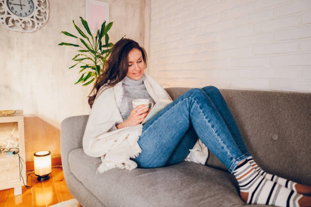 istock A woman is reading a book at home 2058662228